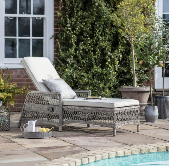 Aurina Menton Sun Lounger in outdoor setting by pool, with decorative pillow and tray