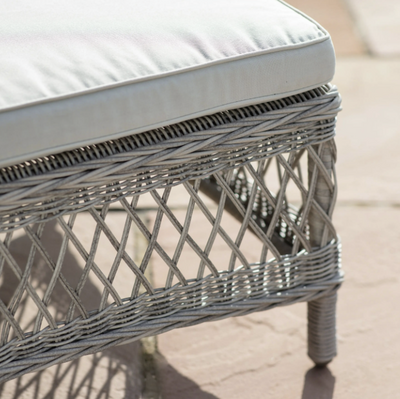 Aurina Menton Sun Lounger with a light cushion and woven grey frame, side view